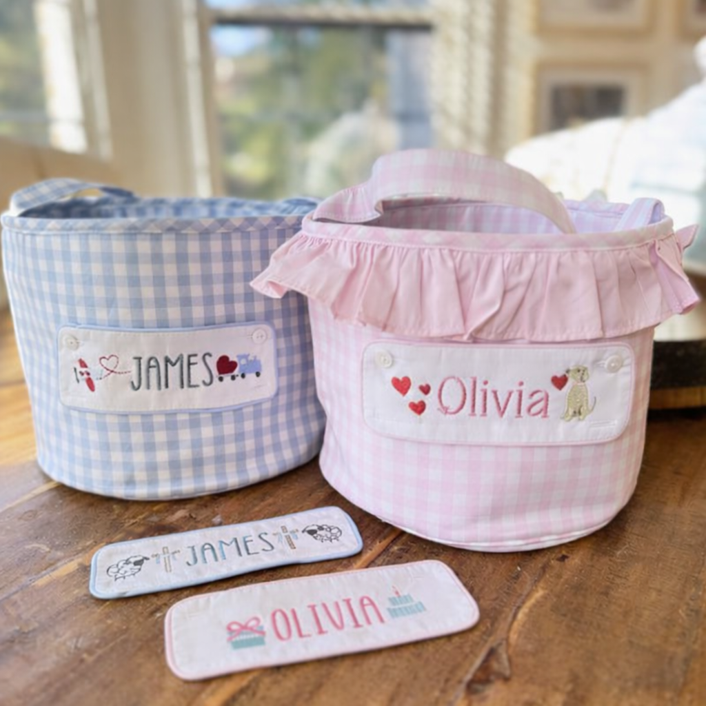 Two fabric baskets, one blue and one pink, with embroidered Valentine's Day images and names 'James' and 'Olivia'
